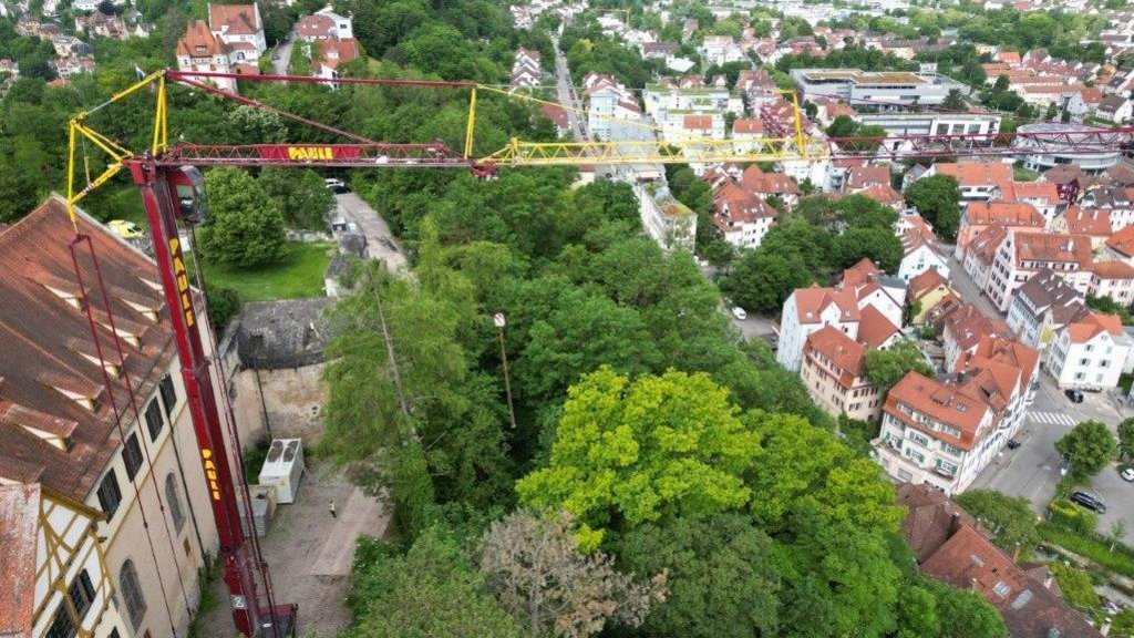 Zu sehen ist ein Kran neben Schloss Hohentübingen sowie eine kleine Panoramaansicht der Stadt Tübingen