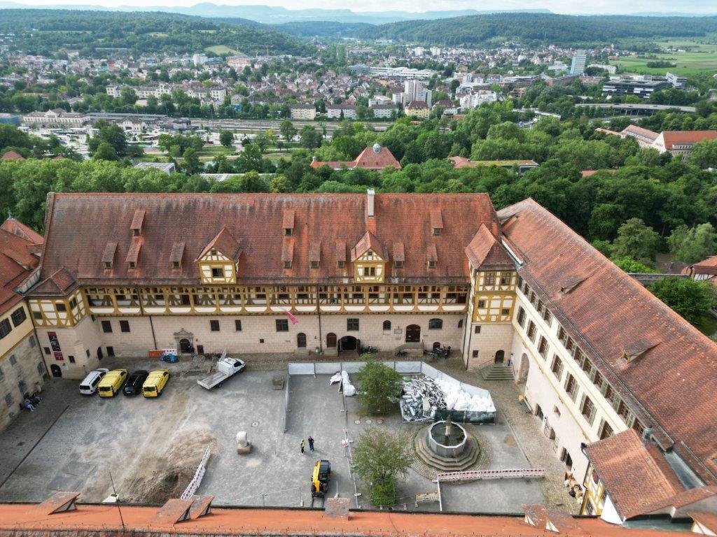 Zu sehen ist eine Luftansicht vom Schlosshof mit Material zum Ausbau der Fernwärmeleitung