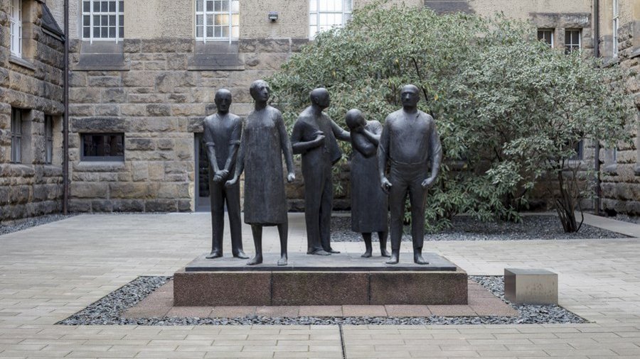 Bronzeplastik auf einem Kunststeinsockel, die fünf Personen zeigt, einander zugestellt, die den kommunistischen Widerstand gegen den Nationalsozialismus verkörpern