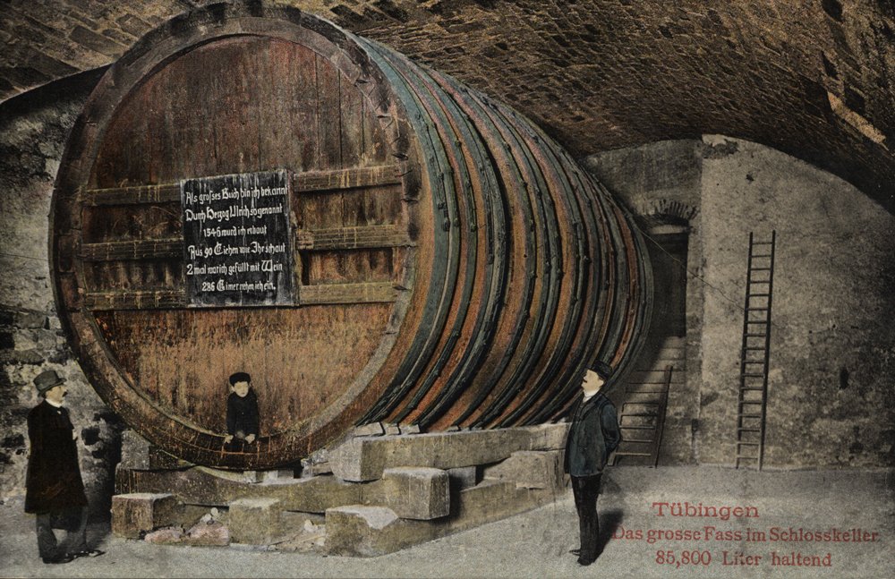 A postcard of the castle barrel, with two men in suits and cylinders standing next to it and a boy looking out from the opening; to the bottom right is the capture "Tübingen//Das grosse Fass im Schlosskeller/85,800 Liter haltend" (Tübingen/the big barrel in the castle cellar/holding 85,88 litres)