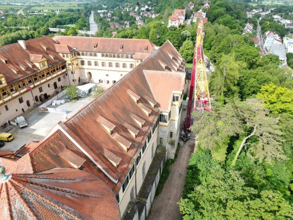 Zu sehen ist ein Kran neben Schloss Hohentübingen sowie eine kleine Panoramaansicht der Stadt Tübingen