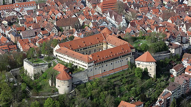 © MUT | Valentin Marquardt Aereal view of Hohentübingen Castle with greenery over the Castle Hill and the red roofs of Tübingen in the background