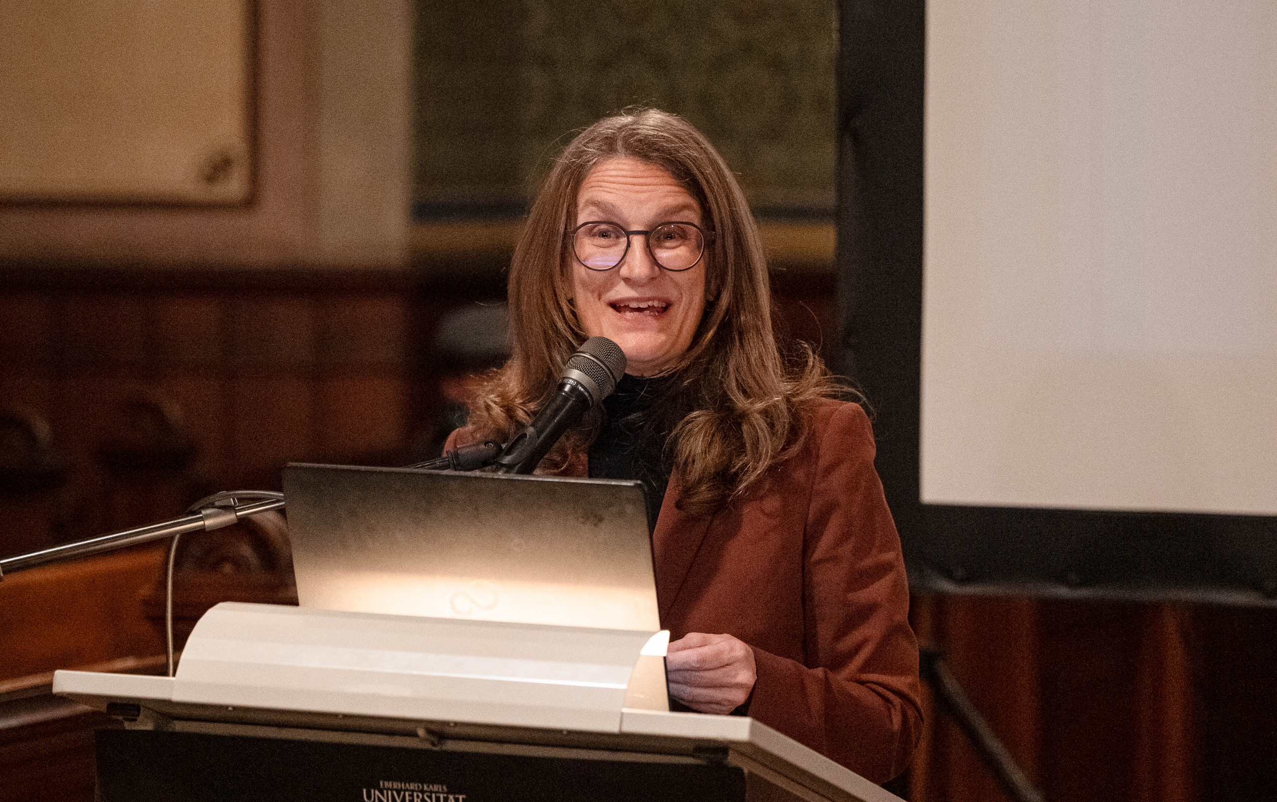 Prof. Dr. Monique Scheerer am Rednerpult vor der Leinwand am Altarbereich der Schlosskirche Hohentübingen