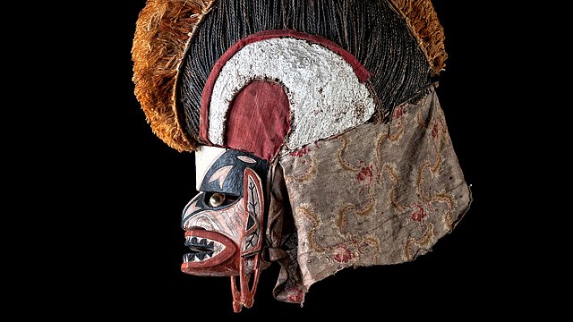 Nach links gewandte Tatanua Malaggan-Maske, bemalt in Schwarz, Weiß und Rot, vor schwarzem Hintergrund