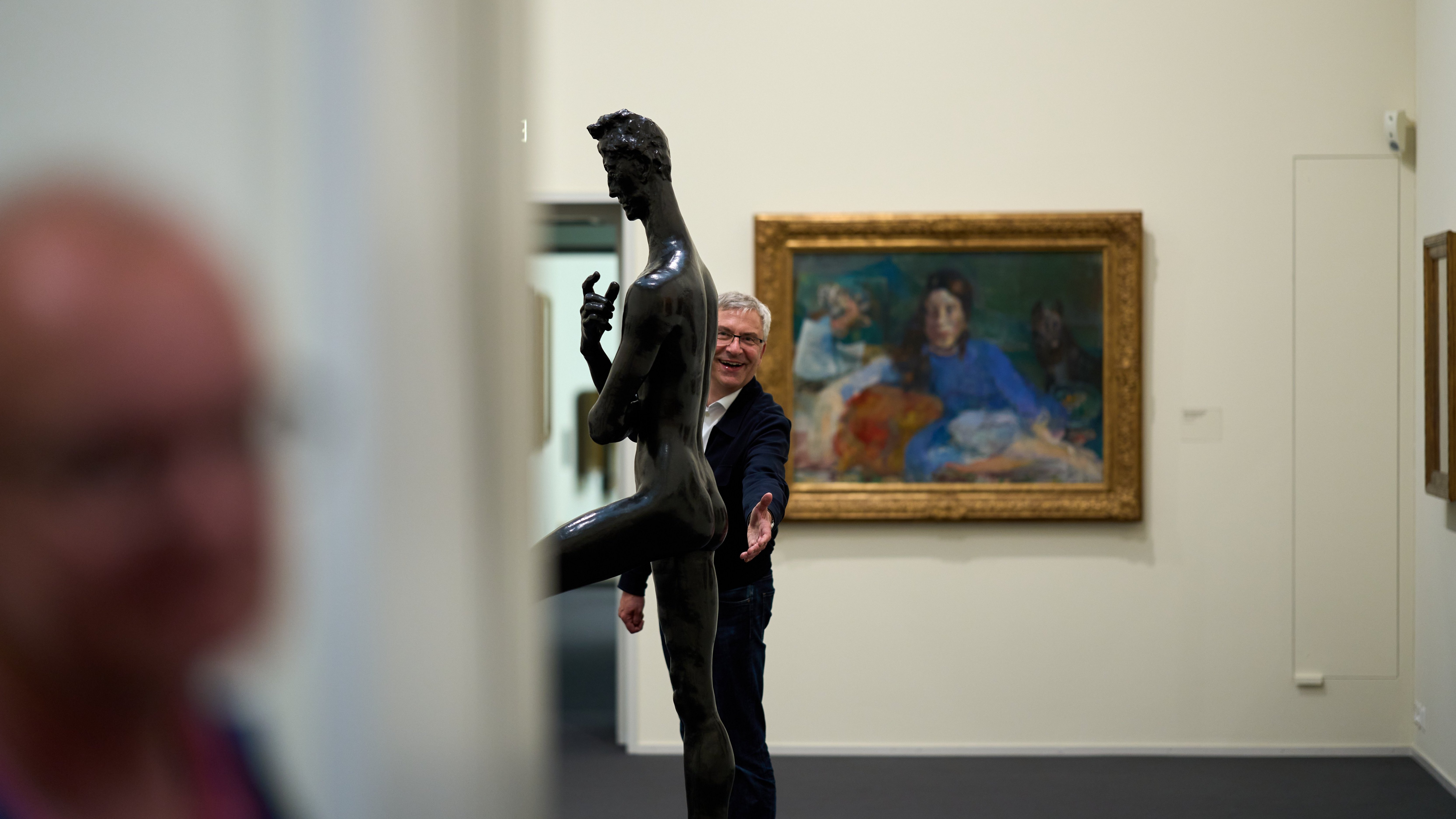 Zu sehen ist Ernst Seidl mit verschmitztem Grinsen der einer Statue seine Hand vor den Po hältKunsthaus Tübingen