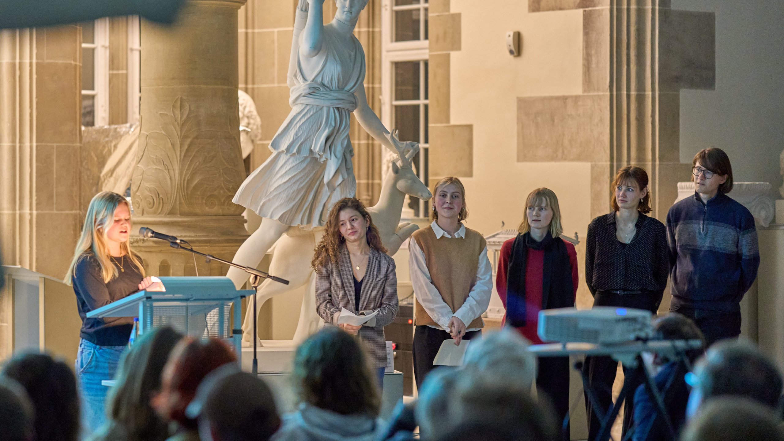 (v. l. n. r.) Leyla Waberski, Diellëza Hyseni, Luisa Beck, Solveig Schreiber, Svenja Hankiewicz und Timon Butz am Rednerpult der Eröffnung „Koloniale Schatten“