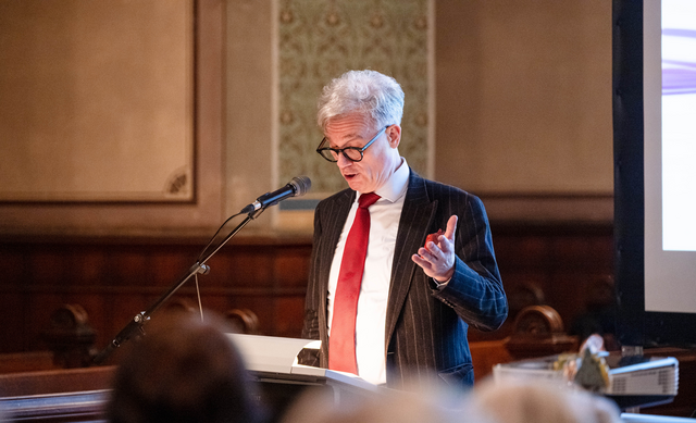 © MUT | Valentin Marquardt Prof. Dr. Thomas Finkenauer at the lectern in front of the altar of Hohentübingen Castle church, his left hand raised in an explaining gesture