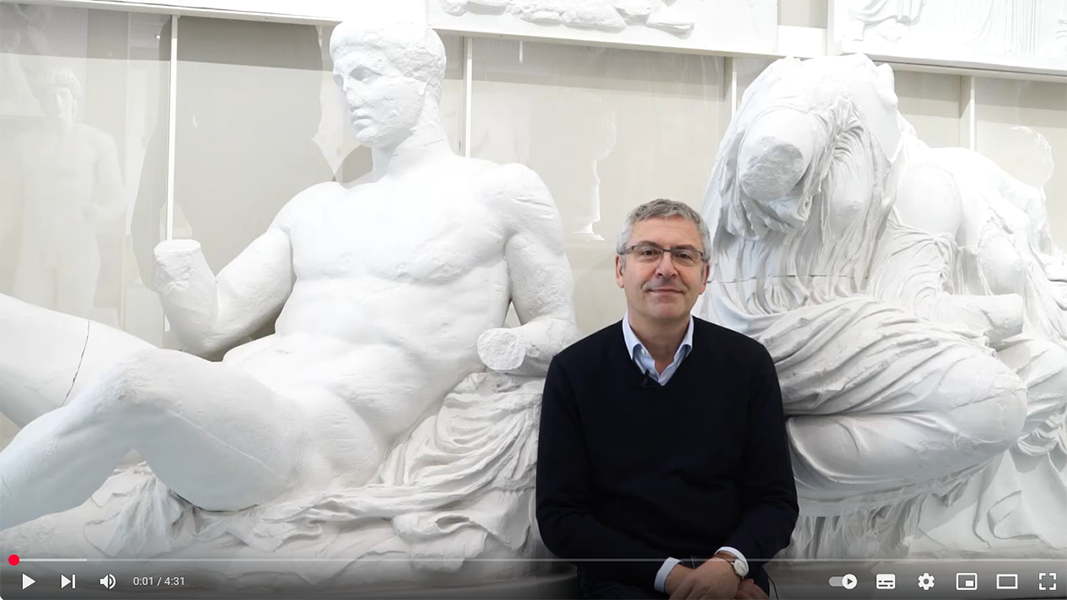 Videoframe von Prof Seidl vor zwei Gipsabgüssen im Museum Alte Kulturen